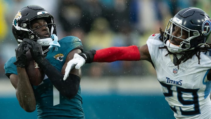Dec 29, 2024; Jacksonville, Florida, USA; Jacksonville Jaguars wide receiver Brian Thomas Jr (7) catches the ball against Tennessee Titans cornerback Jarvis Brownlee Jr. (29) in the second quarter at EverBank Stadium. Mandatory Credit: Jeremy Reper-Imagn Images