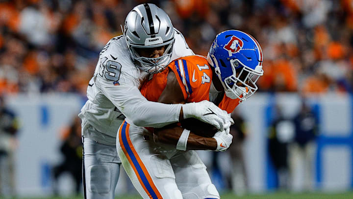 Nov 6, 2025; Denver, Colorado, USA; Denver Broncos wide receiver Courtland Sutton (14) is tackled by Las Vegas Raiders defensive end Charles Snowden (49) in the fourth quarter at Empower Field at Mile High. Mandatory Credit: Isaiah J. Downing-Imagn Images