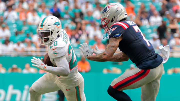 Sep 14, 2025; Miami Gardens, Florida, USA; Miami Dolphins running back De'Von Achane (28) runs with the football against New England Patriots cornerback Carlton Davis III (7) during the third quarter at Hard Rock Stadium. Mandatory Credit: Sam Navarro-Imagn Images Sep 14, 2025; Miami Gardens, Florida, USA; Miami Dolphins running back De'Von Achane (28) runs with the football against New England Patriots cornerback Carlton Davis III (7) during the third quarter at Hard Rock Stadium. Mandatory Credit: Sam Navarro-Imagn Images