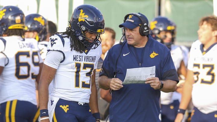 Sep 6, 2025; Athens, Ohio, USA; West Virginia Mountaineers head coach Rich Rodriguez talks with West Virginia Mountaineers quarterback Jaylen Henderson (13) during the fourth quarter against the Ohio Bobcats at Peden Stadium. Mandatory Credit: Ben Queen-Imagn Images