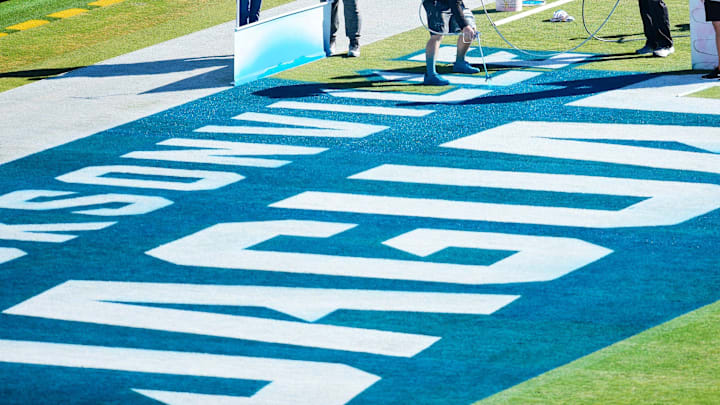 Turf crews from ASM Jacksonville fill in the north end zone of TIAA Bank Field surrounding the Jacksonville Jaguars name with teal paint as they help ready the stadium for Saturday's game against the Tennessee Titans Friday morning, Jan. 6, 2023. Another field change will be the \"Bills Red\" outlines around the threes on the 30 yard lines in support of injured Buffalo Bills player Damar Hamlin, whose uniform number is 3. The victor of Saturday's game will win AFC South Division and will host a