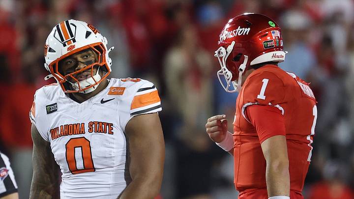 Oklahoma State Cowboys defensive end Malik Charles (0) and Houston Cougars quarterback Conner Weigman. Oklahoma State Cowboys defensive end Malik Charles (0) and Houston Cougars quarterback Conner Weigman.