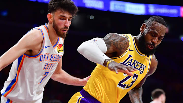 Mar 4, 2024; Los Angeles, California, USA; Los Angeles Lakers forward LeBron James (23) goes for the ball against Oklahoma City Thunder forward Chet Holmgren (7) during the second half at Crypto.com Arena. Mandatory Credit: Gary A. Vasquez-Imagn Images