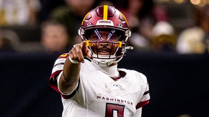 Dec 15, 2024; New Orleans, Louisiana, USA;  Washington Commanders quarterback Jayden Daniels (5) points at New Orleans Saints safety Tyrann Mathieu (32) during the first half at Caesars Superdome. Mandatory Credit: Stephen Lew-Imagn Images