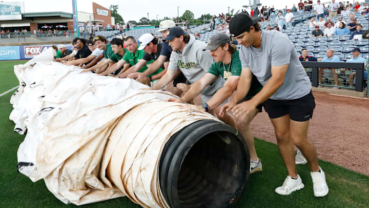 Members of the Belhaven University baseball team roll out a rain cover to protect the baseball diamond at Trustmark Park during the annual Governor's Cup played between Mississippi State University and the University of Mississippi in Pearl, Miss., on Tuesday, April 22, 2025. Members of the Belhaven University baseball team roll out a rain cover to protect the baseball diamond at Trustmark Park during the annual Governor's Cup played between Mississippi State University and the University of Mississippi in Pearl, Miss., on Tuesday, April 22, 2025.