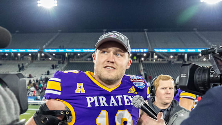 Dec 27, 2022; Birmingham, Alabama, USA; East Carolina Pirates quarterback Holton Ahlers (12) talks with reporters after the 2022 Birmingham Bowl at Protective Stadium. East Carolina won the game 59-23 over the Coastal Carolina Chanticleers. Mandatory Credit: Vasha Hunt-Imagn Images