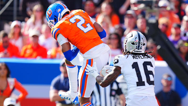 Oct 6, 2024; Denver, Colorado, USA; Denver Broncos cornerback Pat Surtain II (2) pulls in a interception intended for Las Vegas Raiders wide receiver Jakobi Meyers (16) in the second quarter at Empower Field at Mile High. 