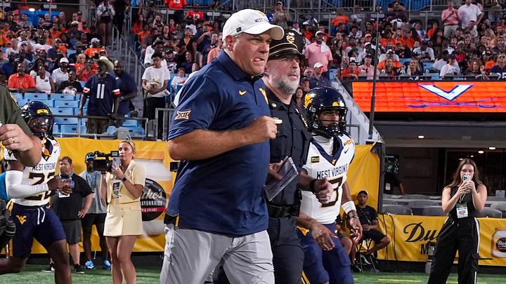 Sep 19, 2026; Charlotte, North Carolina, USA; West Virginia Mountaineers head coach Rich Rodriguez leads his team onto the field against the Virginia Cavaliers during the first quarter at Bank of America Stadium. Mandatory Credit: Jim Dedmon-Imagn Images Sep 19, 2026; Charlotte, North Carolina, USA; West Virginia Mountaineers head coach Rich Rodriguez leads his team onto the field against the Virginia Cavaliers during the first quarter at Bank of America Stadium. Mandatory Credit: Jim Dedmon-Imagn Images