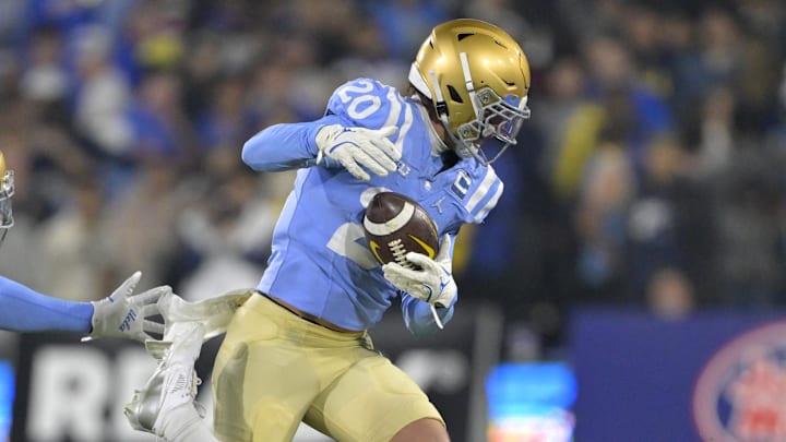 Nov 8, 2024; Pasadena, California, USA;   UCLA Bruins linebacker Kain Medrano (20) strips the ball from Iowa Hawkeyes quarterback Brendan Sullivan (1) giving the Bruins possession in the first half at the Rose Bowl. Mandatory Credit: Jayne Kamin-Oncea-Imagn Images