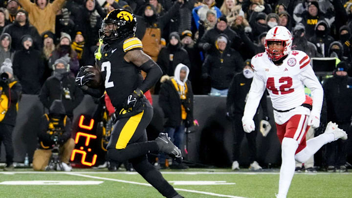 Iowa running back Kaleb Johnson runs to the endzone to score a touchdown as Nebraska linebacker Mikai Gbayor trails.