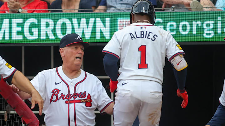 Former Atlanta Braves manager Brian Snitker (43) talks to second baseman Ozzie Albies (1) after scoring a run against the Detroit Tigers in the first inning at Truist Park. Mandatory Credit: Brett Davis-Imagn Images