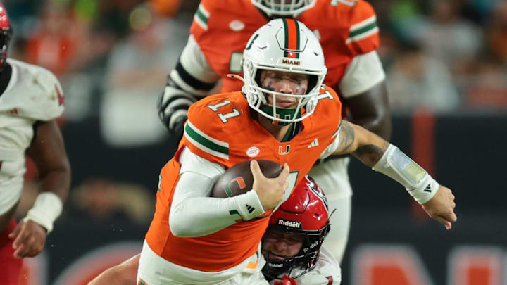 Nov 15, 2025; Miami Gardens, Florida, USA; Miami Hurricanes quarterback Carson Beck (11) carries the football against NC State Wolfpack linebacker Caden Fordham (1) during the third quarter at Hard Rock Stadium. Mandatory Credit: Sam Navarro-Imagn Images