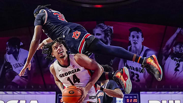 Georgia Bulldogs forward Asa Newell (14) got Auburn Tigers forward Chaney Johnson flipping over his back in a desperate attempt to stop an easy basket on Saturday at Stegeman Coliseum in Athens, Ga. The Bulldogs missed a last-season shot that would've forced overtime.