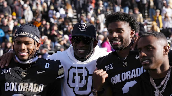Nov 29, 2024; Boulder, Colorado, USA; Colorado Buffaloes safety Shilo Sanders (21) and head coach Deion Sanders and quarterback Shedeur Sanders (2) and social media producer Deion Sanders Jr. following the win against the Oklahoma State Cowboys at Folsom Field. Mandatory Credit: Ron Chenoy-Imagn Images