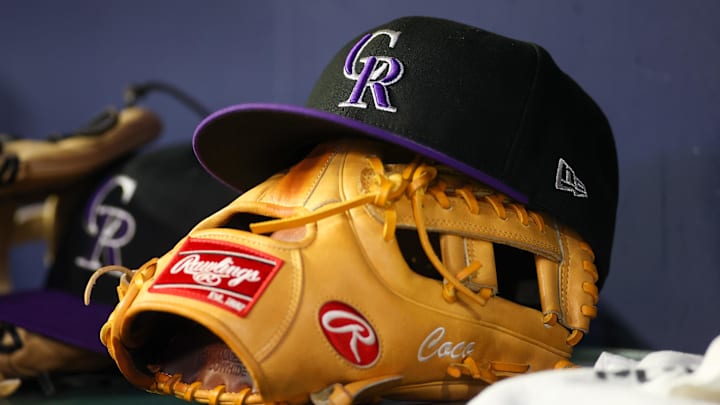 A detailed view of a Colorado Rockies hat and glove on the bench against the Atlanta Braves in the ninth inning at Truist Park. 