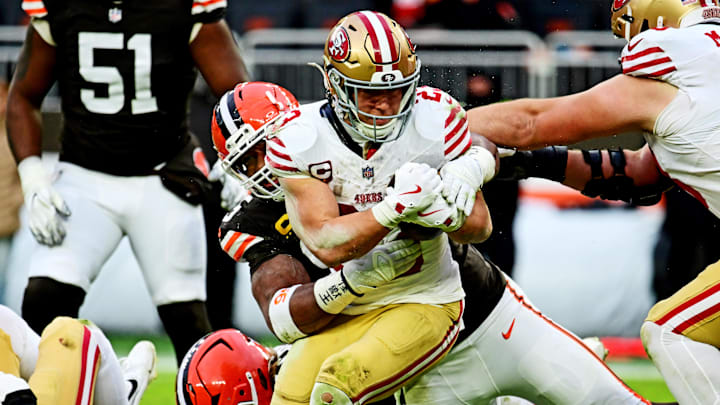 Nov 30, 2025; Cleveland, Ohio, USA;  San Francisco 49ers running back Christian McCaffrey (23) is tackled by Cleveland Browns defensive end Myles Garrett (95) during the second half at Huntington Bank Field. Mandatory Credit: Ken Blaze-Imagn Images
