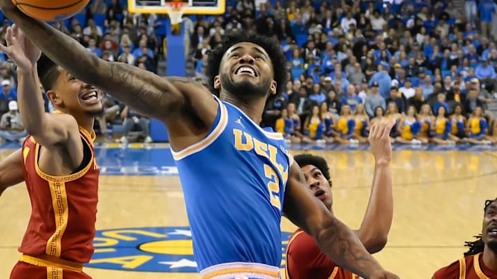 Feb 24, 2026; Los Angeles, California, USA; UCLA Bruins guard Donovan Dent (2) grabs a rebound away from Southern California Trojans guard Chad Baker-Mazara (4) during the first half at Pauley Pavilion presented by Wescom Financial. Mandatory Credit: Robert Hanashiro-Imagn Images
