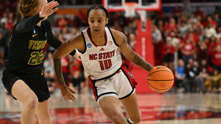 Mar 22, 2025; Raleigh, North Carolina, USA; NC State Wolfpack guard Aziaha James (10) drives around Vermont Catamounts guard Sarah Ericson (22) during the second half at James T. Valvano Arena at William Neal Reynolds. Mandatory Credit: William Howard-Imagn Images