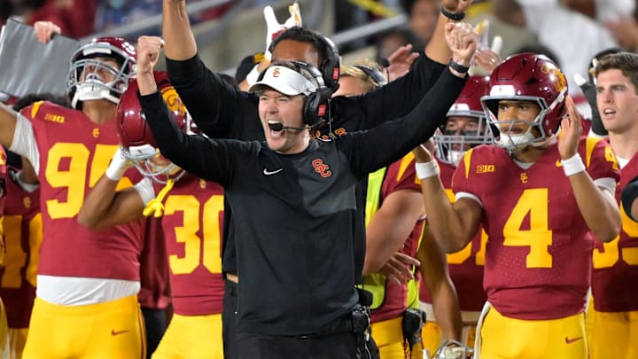 Oct 11, 2025; Los Angeles, California, USA;  USC Trojans head coach Lincoln Riley (wearing white visor) celebrates along with defensive end coach Shaun Nua after kicker Ryon Sayeri (48) hit a 54-yard field goal in the second half against the Michigan Wolverines at United Airlines Field at the Los Angeles Memorial Coliseum. Mandatory Credit: Jayne Kamin-Oncea-Imagn Images
