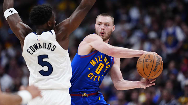 Apr 20, 2026; Denver, Colorado, USA; Denver Nuggets guard Christian Braun (0) looks to pass the ball past Minnesota Timberwolves guard Anthony Edwards (5) in the second half during game two of the first round of the 2026 NBA Playoffs at Ball Arena. Mandatory Credit: Ron Chenoy-Imagn Images