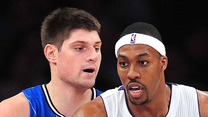 Los Angeles Lakers center Dwight Howard controls the ball against the defense of Orlando Magic center Nikola Vucevic. Los Angeles Lakers center Dwight Howard controls the ball against the defense of Orlando Magic center Nikola Vucevic.