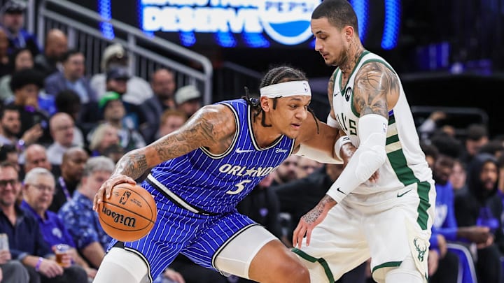 Feb 9, 2026; Orlando, Florida, USA; Orlando Magic forward Paolo Banchero (5) drives against Milwaukee Bucks forward Kyle Kuzma (18) during the first quarter at Kia Center. Mandatory Credit: Mike Watters-Imagn Images