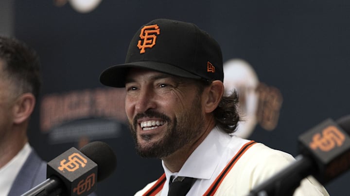 Oct 30, 2025; San Francisco, CA, USA;  Tony Vitello (center) answers questions from the media as he is introduced as the new manager of the San Francisco Giants at Oracle Park. He is flanked by president of baseball operations Buster Posey (left) and general manager Zack Minasian. Mandatory Credit: D. Ross Cameron-Imagn Images