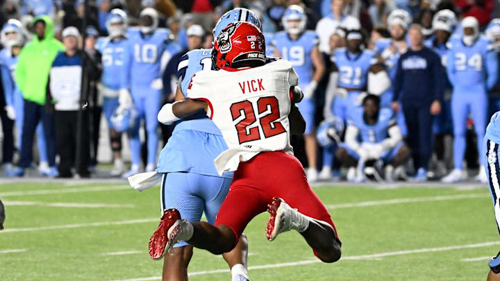 Nov 30, 2024; Chapel Hill, North Carolina, USA; North Carolina State Wolfpack cornerback Jackson Vick (22) sacks North Carolina Tar Heels quarterback Jacolby Criswell (12) leaving 7 seconds in the fourth quarter at Kenan Memorial Stadium. Mandatory Credit: Bob Donnan-Imagn Images
