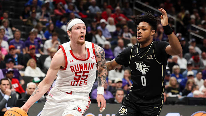 Mar 11, 2025; Kansas City, MO, USA; Utah Utes guard Gabe Madsen (55) drives to the basket around UCF Knights guard Jordan Ivy-Curry (0) during the first half at T-Mobile Center. Mandatory Credit: William Purnell-Imagn Images