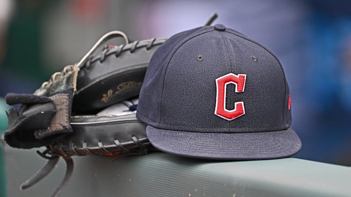 Jun 27, 2024; Kansas City, Missouri, USA; A general view a Cleveland Guardians hat and glove on the dugout railing  before a game against the Kansas City Royals at Kauffman Stadium. Mandatory Credit: Peter Aiken-Imagn Images