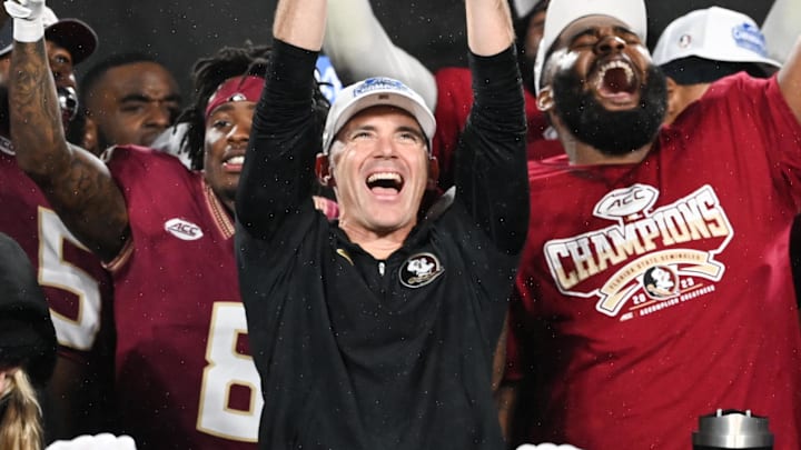 Dec 2, 2023; Charlotte, NC, USA; Florida State Seminoles head coach Mike Norvell raises the ACC Championship trophy with his players after the game against the Louisville Cardinals at Bank of America Stadium. Mandatory Credit: Bob Donnan-Imagn Images