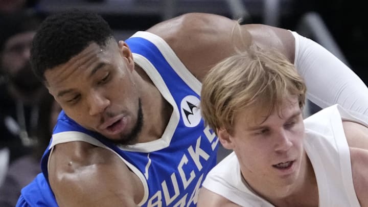 Milwaukee Bucks forward Giannis Antetokounmpo attempts to grab the ball away from Toronto Raptors guard Gradey Dick. Milwaukee Bucks forward Giannis Antetokounmpo attempts to grab the ball away from Toronto Raptors guard Gradey Dick.