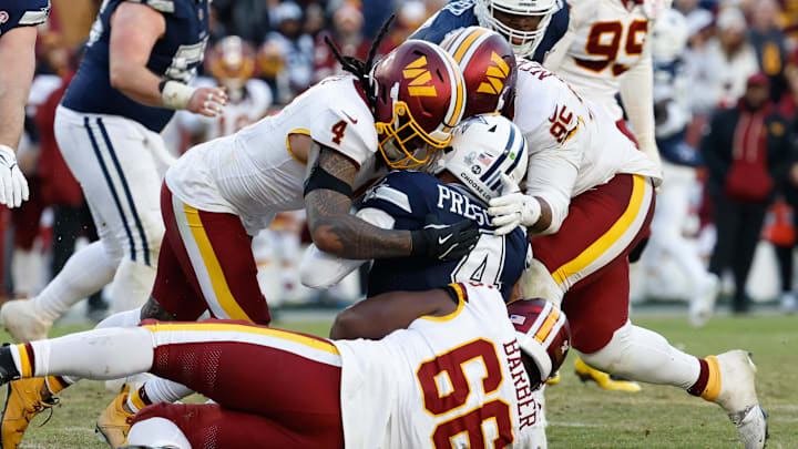 Dec 25, 2025; Landover, Maryland, USA; Washington Commanders linebacker Frankie Luvu (4), defensive tackle Ricky Barber (66) and defensive tackle Jer'Zhan Newton (95) tackle Dallas Cowboys quarterback Dak Prescott (4) in the fourth quarter at Northwest Stadium. Mandatory Credit: Geoff Burke-Imagn Images