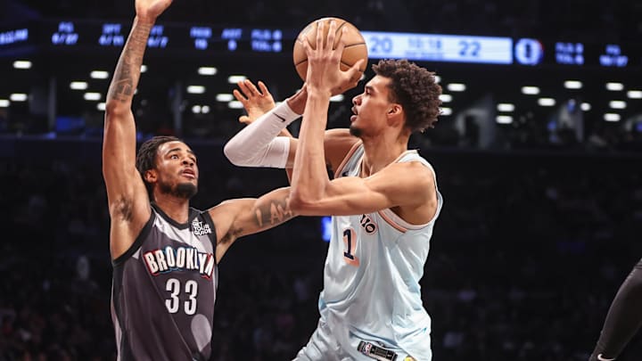 Dec 27, 2024; Brooklyn, New York, USA; San Antonio Spurs center Victor Wembanyama (1) prepares to shoot past Brooklyn Nets center Nic Claxton (33) in the second quarter at Barclays Center.