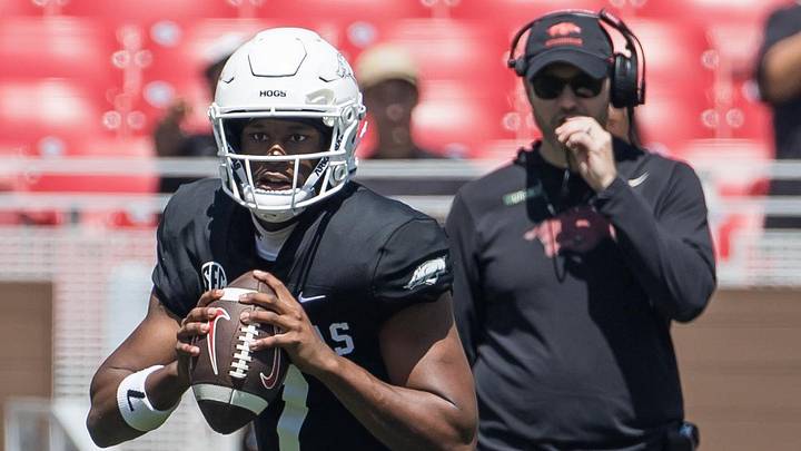 Arkansas Razorbacks quarterback KJ Jackson (7) rolls out to pass as coach Ryan Silverfield looks on during the spring game at Razorback Stadium. 