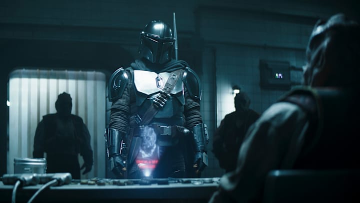 (Center): The Mandalorian (Pedro Pascal) Kaba Baiz (seated, far right) and Klatooinians in a scene from Lucasfilm's THE BOOK OF BOBA FETT, exclusively on Disney+. © 2022 Lucasfilm Ltd. & ™. All Rights Reserved.