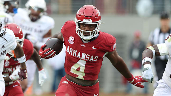 Oct 18, 2025; Fayetteville, Arkansas, USA; Arkansas Razorbacks running back Mike Washington Jr (4) rushes in the second quarter as Texas A&M Aggies cornerback Tyreek Chappell (7) and safety Dalton Brooks (25) defend at Donald W. Reynolds Razorback Stadium. Mandatory Credit: Nelson Chenault-Imagn Images