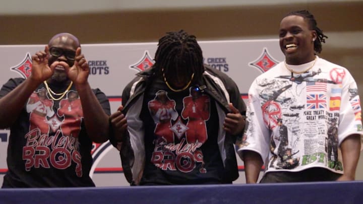 Amari Latimer commits to the University of Wisconsin at Sandy Creek High School. Pictured to his left is his father (Gee Latimer) and pictured to his right is his older brother (Geimer Latimer) 