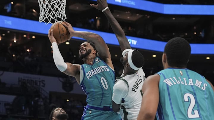 Feb 29, 2024; Charlotte, North Carolina, USA; Charlotte Hornets forward Miles Bridges (0) is fouled going for a shot by Milwaukee Bucks forward Bobby Portis (9) during the second half at Spectrum Center. Mandatory Credit: Jim Dedmon-Imagn Images