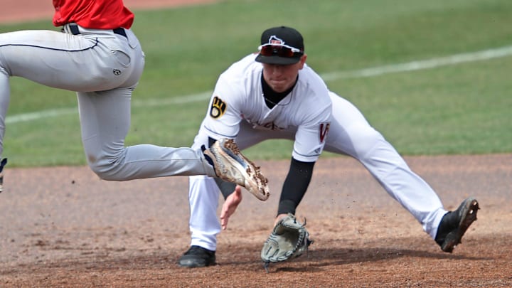 Cedar Rapids Kernels' Luke Keaschall (44) hurdles the ball as Wisconsin Timber Rattlers' Mike Boeve (19) fields it during their baseball game Wednesday, April 17, 2024, at Neuroscience Group Field at Fox Cities Stadium in Grand Chute, Wisconsin.