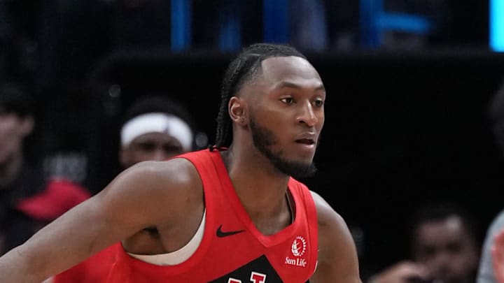 Dallas Mavericks guard Max Christie passes the ball as Toronto Raptors guard Immanuel Quickley tries to defend.