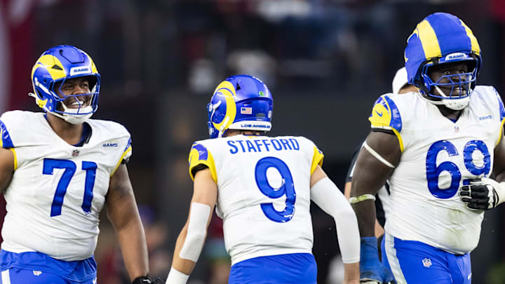 Dec 7, 2025; Glendale, Arizona, USA; Los Angeles Rams quarterback Matthew Stafford (9) celebrates a touchdown with offensive lineman Warren McClendon Jr. (71) and Kevin Dotson (69) against the Arizona Cardinals at State Farm Stadium. Mandatory Credit: Mark J. Rebilas-Imagn Images Dec 7, 2025; Glendale, Arizona, USA; Los Angeles Rams quarterback Matthew Stafford (9) celebrates a touchdown with offensive lineman Warren McClendon Jr. (71) and Kevin Dotson (69) against the Arizona Cardinals at State Farm Stadium. Mandatory Credit: Mark J. Rebilas-Imagn Images