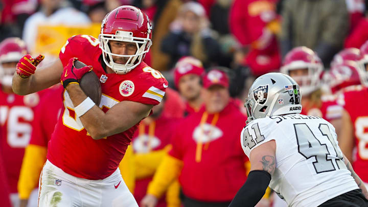 Nov 29, 2024; Kansas City, Missouri, USA; Kansas City Chiefs tight end Travis Kelce (87) runs with the ball against Las Vegas Raiders linebacker Robert Spillane (41) during the first half at GEHA Field at Arrowhead Stadium. Mandatory Credit: Jay Biggerstaff-Imagn Images
