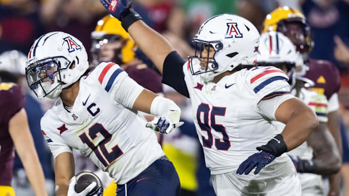 Nov 28, 2025; Tempe, Arizona, USA; Arizona Wildcats defensive back Genesis Smith (12) celebrates a fumble recovery with defensive lineman Leroy Palu (95) in the second half against the Arizona State Sun Devils in the 99th Territorial Cup at Mountain America Stadium. Mandatory Credit: Mark J. Rebilas-Imagn Images