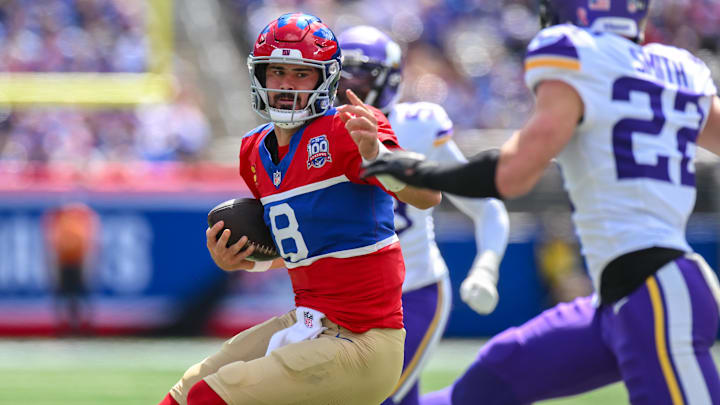 Sep 8, 2024; East Rutherford, New Jersey, USA; New York Giants quarterback Daniel Jones (8) carries the ball while being defended by Minnesota Vikings safety Harrison Smith (22) during the first half at MetLife Stadium.