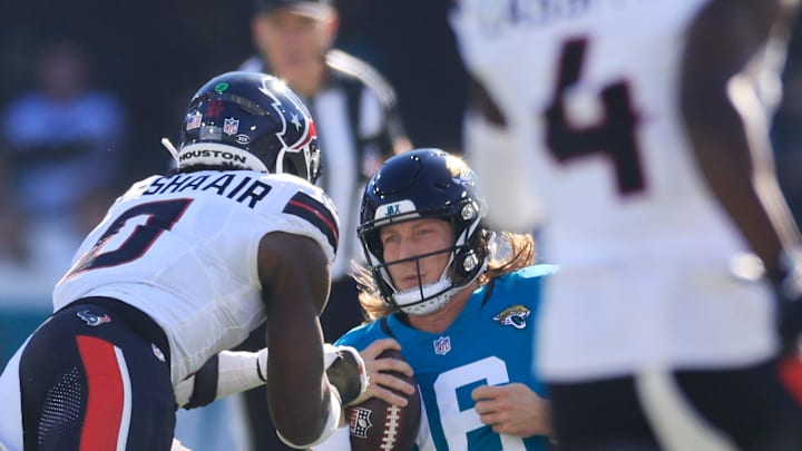 Jacksonville Jaguars quarterback Trevor Lawrence (16) slides for a down as Houston Texans linebacker Azeez Al-Shaair (0) makes a late hit during the second quarter of an NFL football matchup Sunday, Dec. 1, 2024 at EverBank Stadium in Jacksonville, Fla. [Corey Perrine/Florida Times-Union]