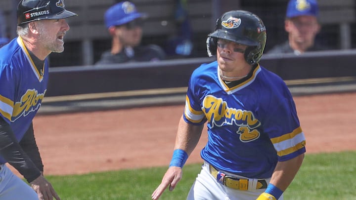 RubberDucks’ Travis Bazzana runs past manager Greg DiCenzo to score a run against the Altoona Curve on April 13, 2025, in Akron, Ohio.
