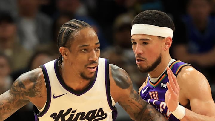 Mar 14, 2025; Phoenix, Arizona, USA; Sacramento Kings forward DeMar DeRozan (10) dribbles the ball against Phoenix Suns guard Devin Booker (1) during the first half at Footprint Center. Mandatory Credit: Mark J. Rebilas-Imagn Images