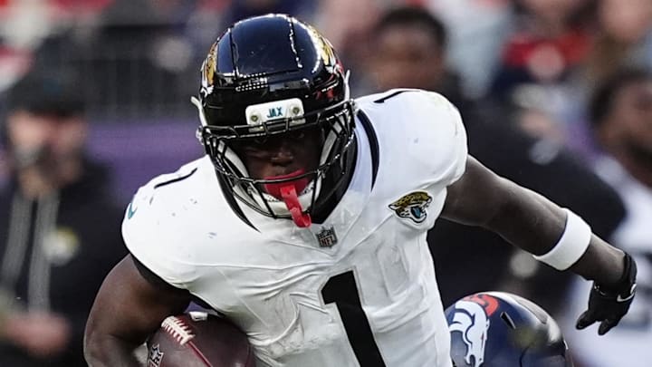 Dec 21, 2025; Denver, Colorado, USA; Jacksonville Jaguars running back Travis Etienne (1) rushes the ball against the Denver Broncos during the second half at Empower Field at Mile High. Mandatory Credit: Ron Chenoy-Imagn Images
