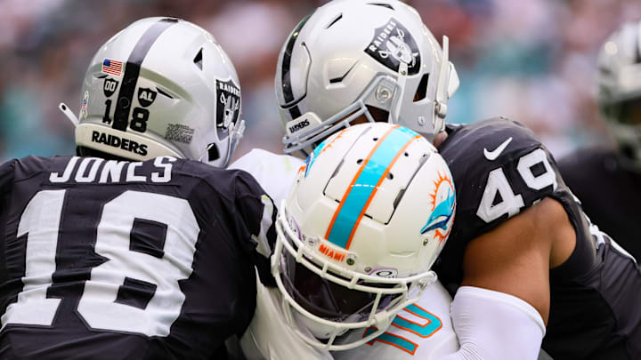 Nov 17, 2024; Miami Gardens, Florida, USA; Miami Dolphins wide receiver Tyreek Hill (10) runs with the football against Las Vegas Raiders cornerback Jack Jones (18) and defensive end Charles Snowden (49) during the third quarter at Hard Rock Stadium. Mandatory Credit: Sam Navarro-Imagn Images